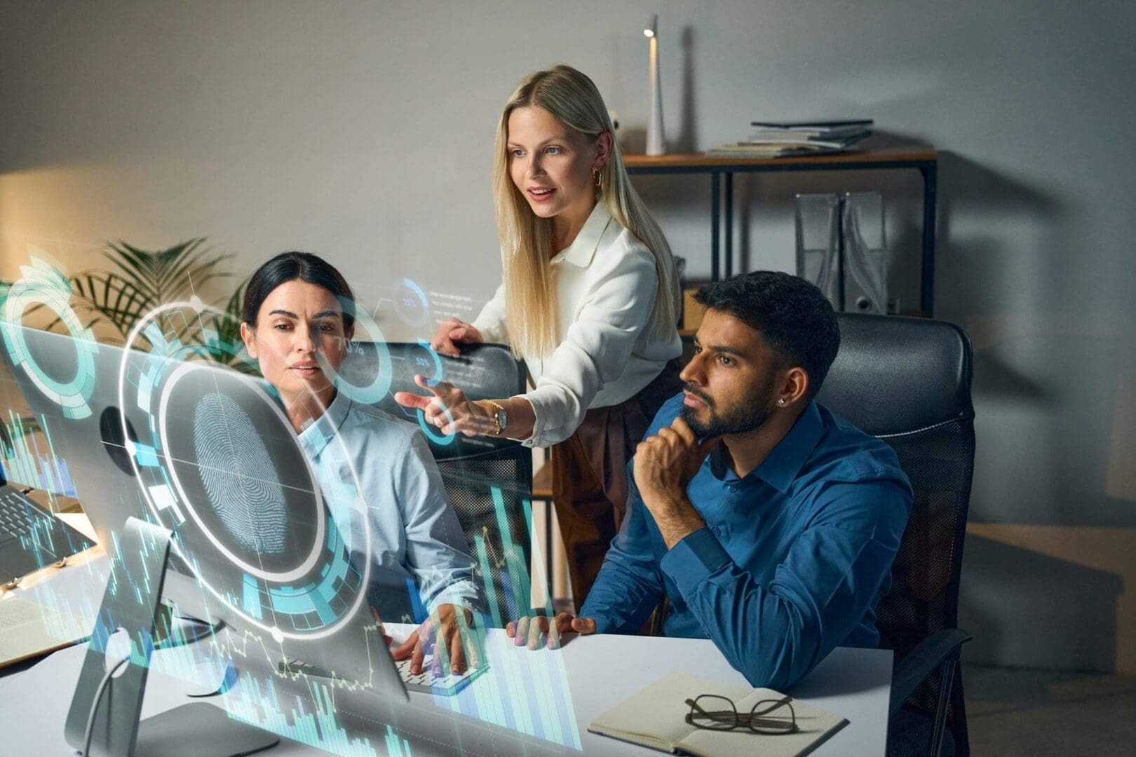 Three coworkers collaborating on a project with a digital interface.
